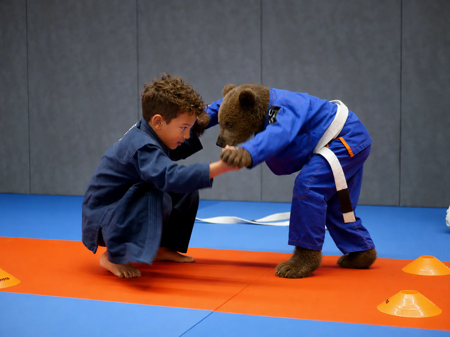Enfant s’exerçant au Jiu-Jitsu avec l’ourson Strongbear
